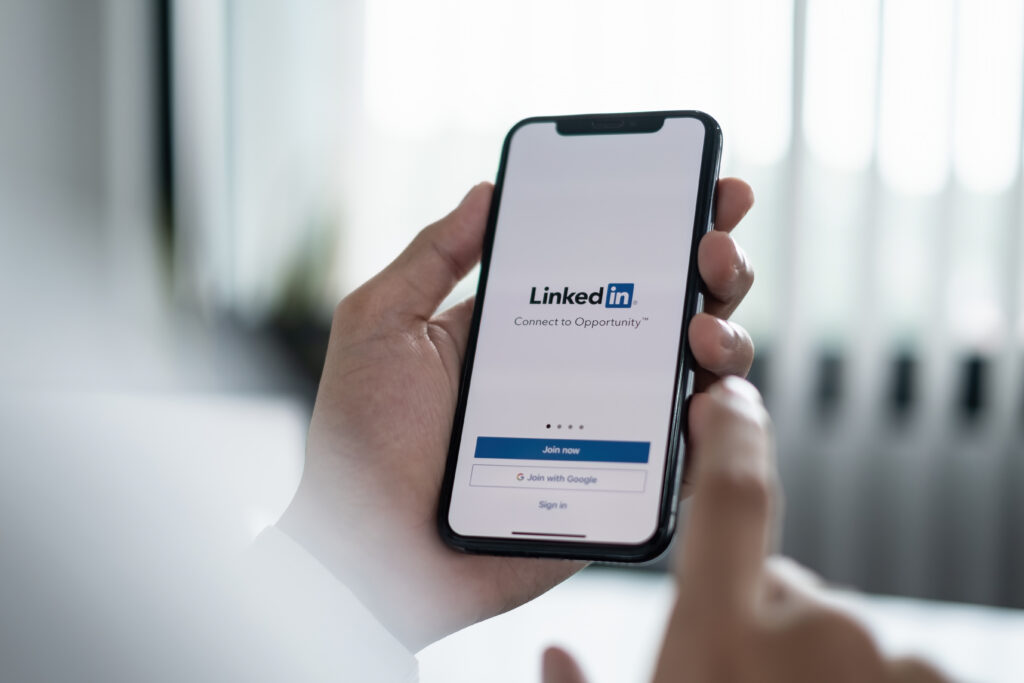 A man logs in to LinkedIn on his phone.